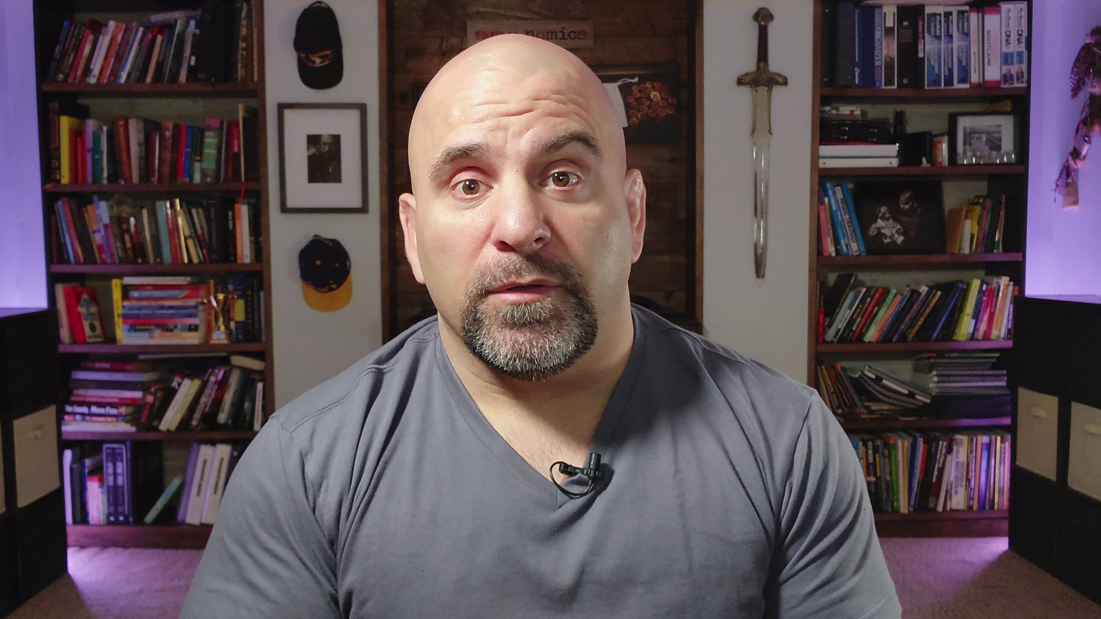 Master Chim talking to the camera in front of his bookshelves