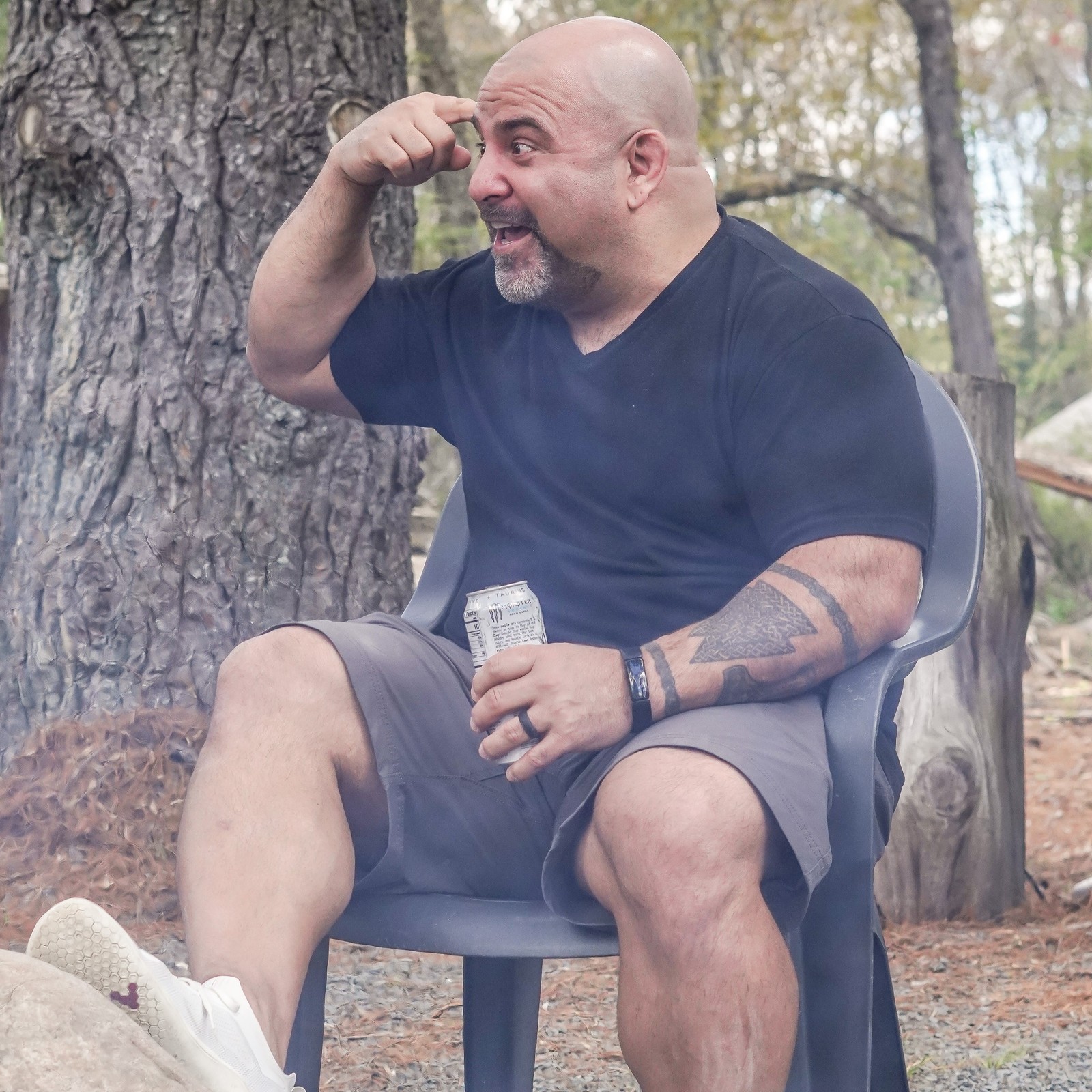 Master Chim seated outdoors, pointing to his head