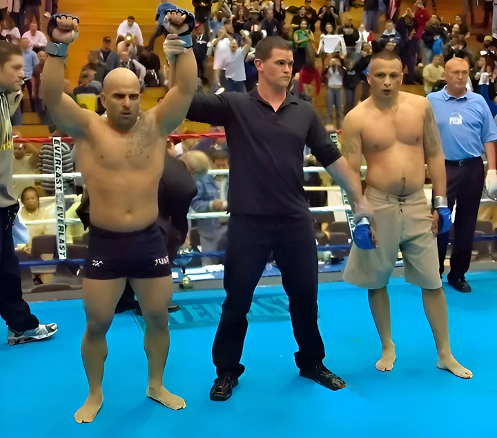 Master Chim in the ring after a fight, the referee raising his arm