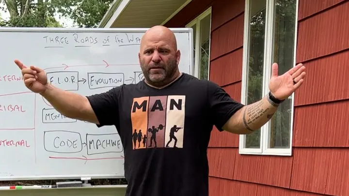 Master Chim teaching at a whiteboard outside, arms spread wide